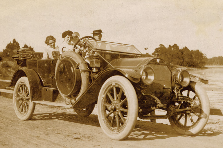 People enjoying a ride in a Hudson motor car circa 1913, which has its steering wheel on the right side.