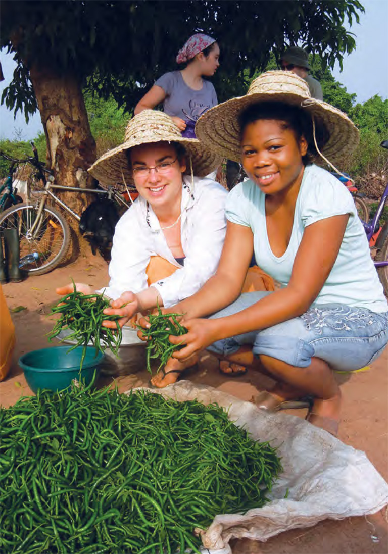 Colour photo of two young women tending a garden.