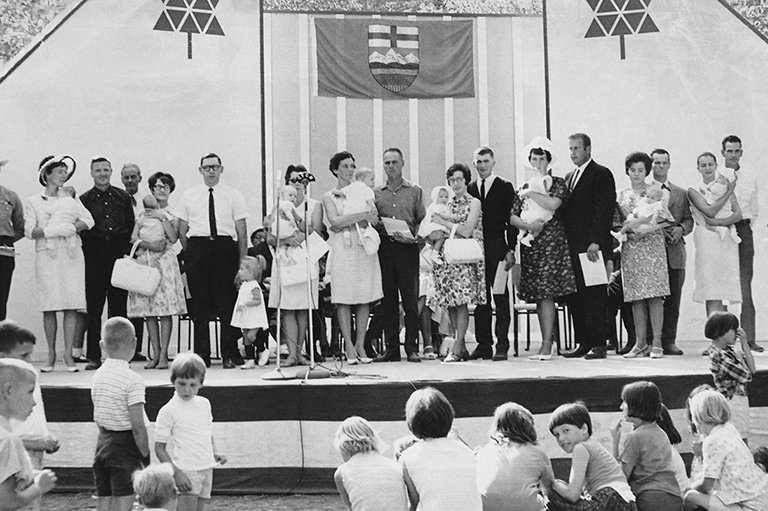 This image shows parents and their children standing on a stage. 