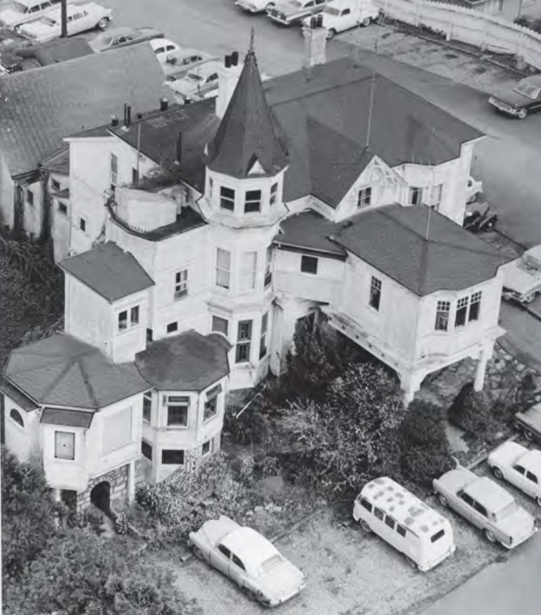 Black and white aerial photo of a large white mansion.
