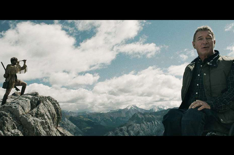 Video still with Rick Hansen in the foreground, and actor portraying David Thompson in the background.