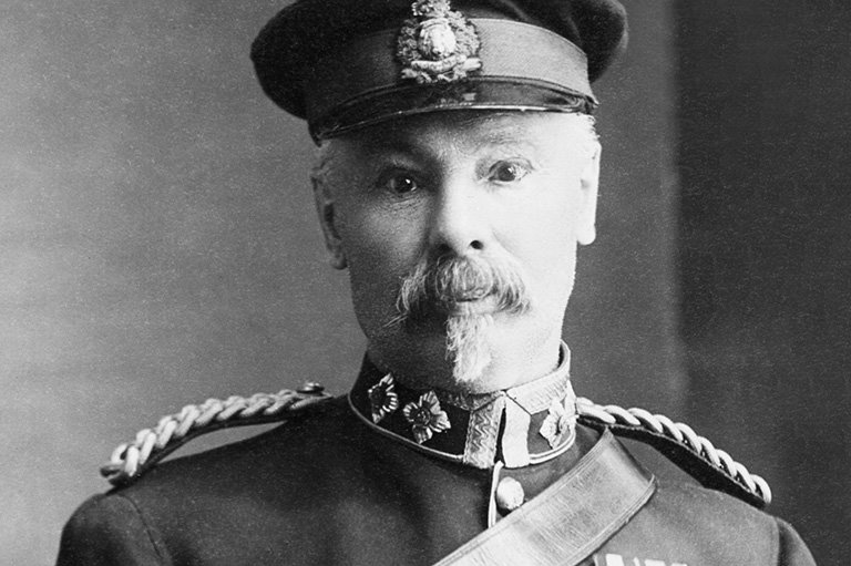 Black and white portrait of a man in a police uniform with medals and a hat. He also has a moustache and a goatee.