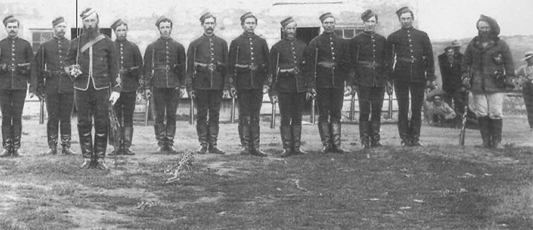 Uniformed men standing in a row. 