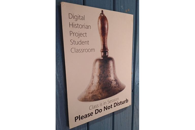 Image shows a photo of a sign with a bell on it. 