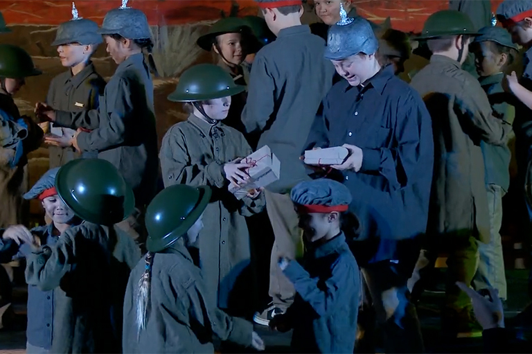 This image shows student performing the exchange of gifts between the German and Allied forces during the Christmas Truce of the First World War.