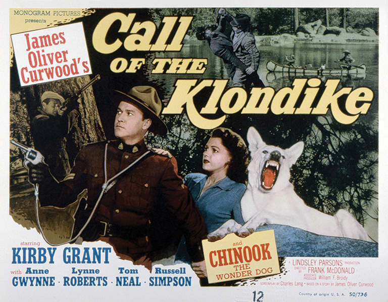 Movie poster showing a man in a police uniform, a woman in a blue dress and a white dog with its mouth open and teeth showing. The poster reads "Call of the Klondike."