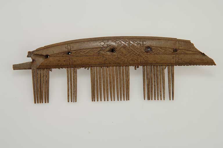 This image shows a comb made out of bone/antler and is decorated on both sides. 
