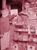 1950s-era scene of two children putting change in a container.