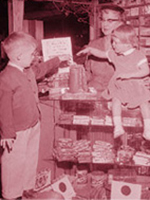 1950s-era scene of two children putting change in a container.