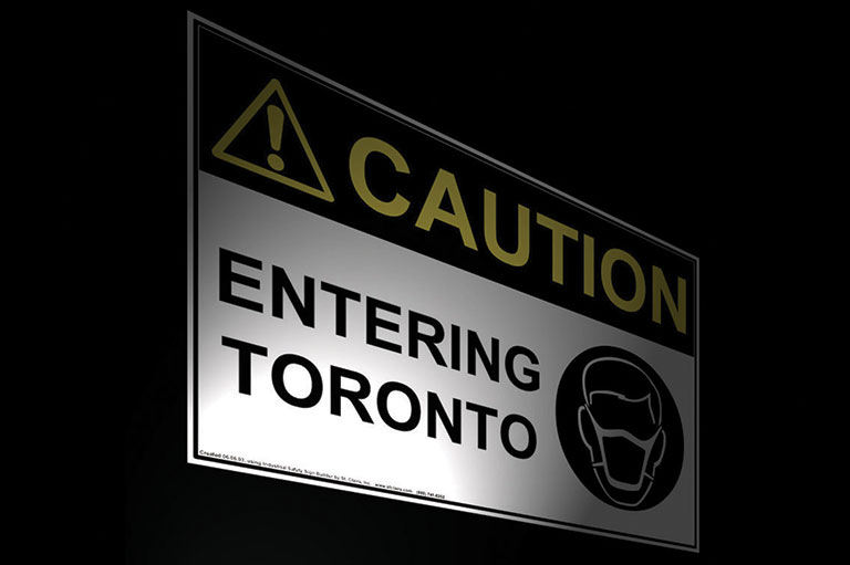 A sign reads: Caution, Entering Toronto. 
