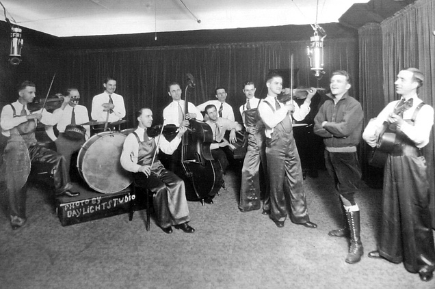 Eleven musician ensemble playing various instruments.