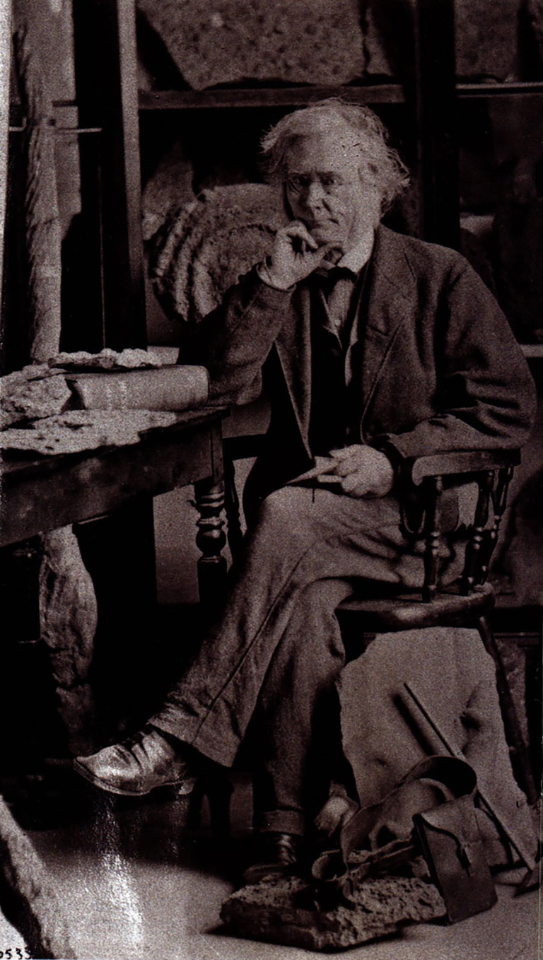 A man sits in a chair beside a table