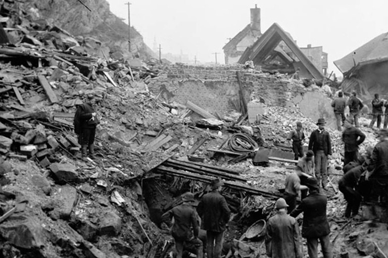 People checking out the damage of a rock slide. 