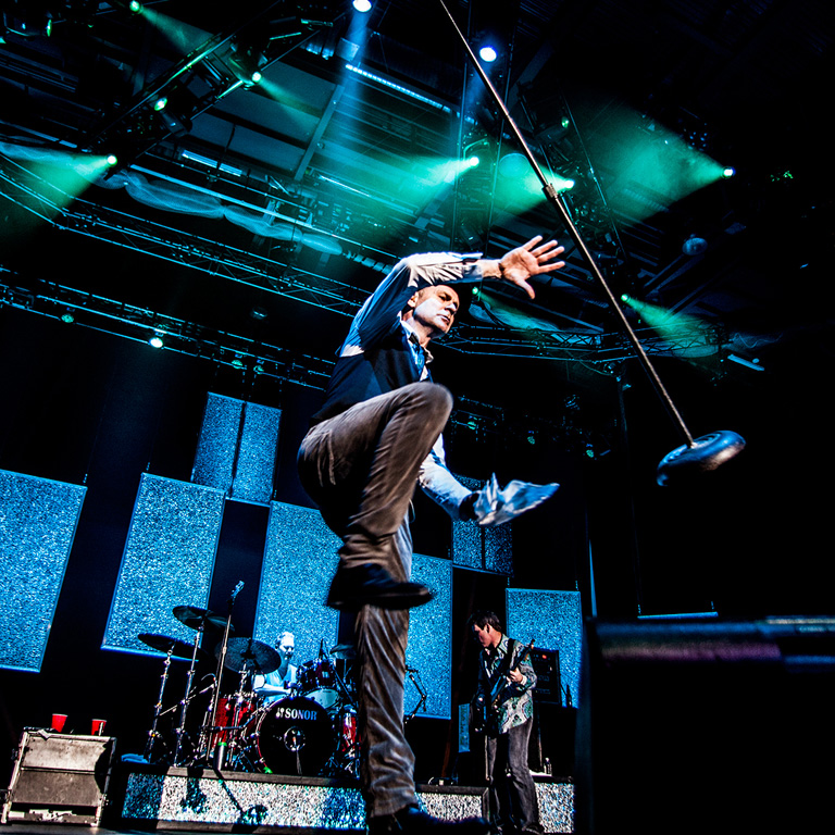 Gord Downie at 2013 concert jumping in mid-air.